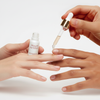 Person applying a dropper of liquid to another person's nail with a bottle labeled 'Aragan' on a white background.