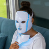 Woman wearing a futuristic white and blue face mask with IGIA branding.