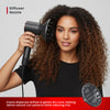 Woman using a hair dryer with a diffuser nozzle on a plain background